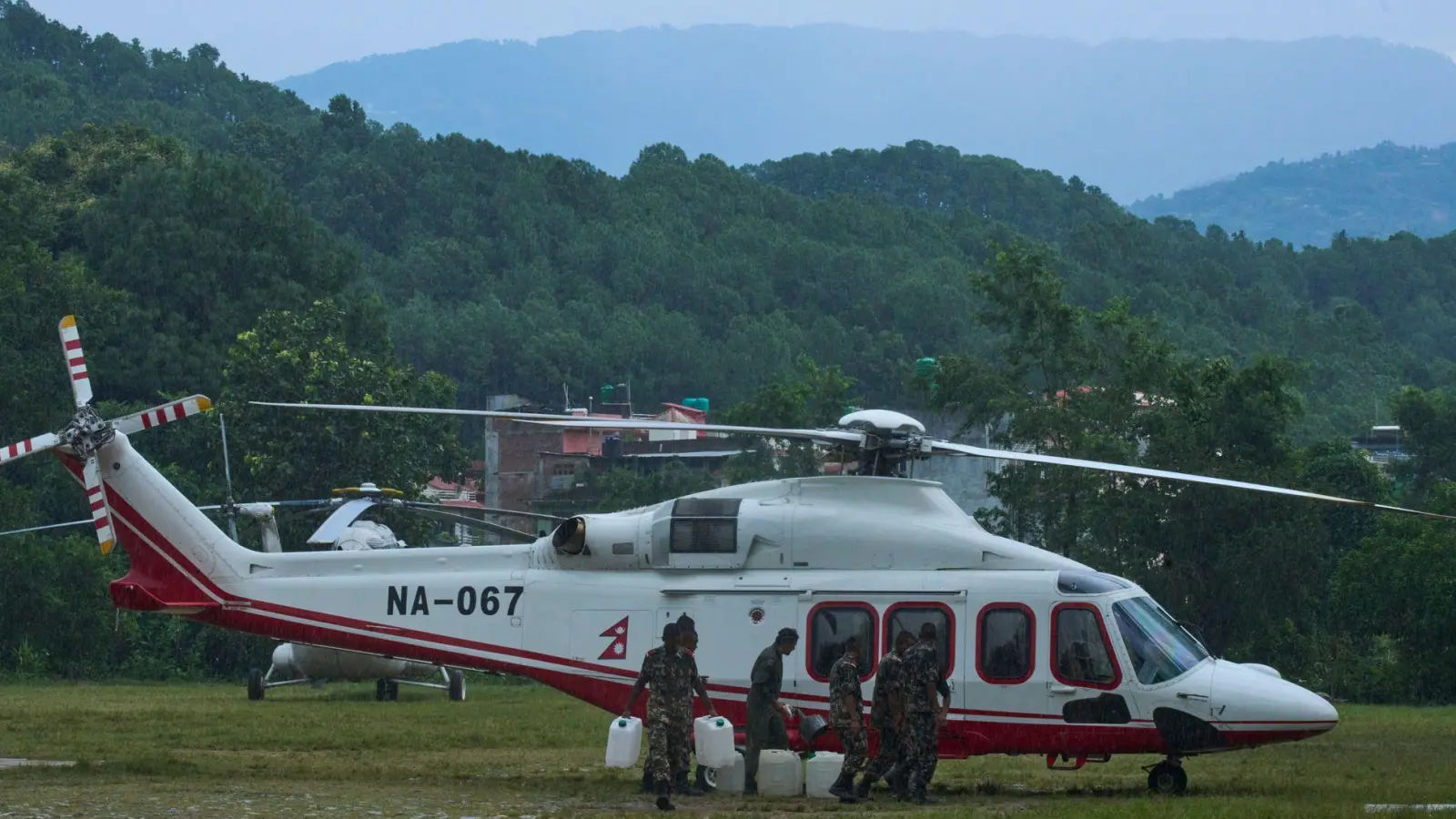 Soldaten der nepalesischen Armee betanken einen Hubschrauber, bevor dieser zu einem Rettungseinsatz nach den Sturzfluten abhebt. (Foto: Niranjan Shrestha/AP/dpa)