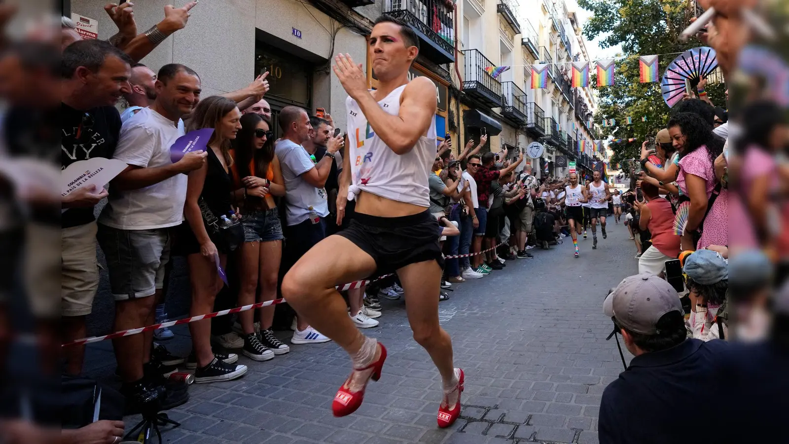 Mit großen Schritten rennt ein Teilnehmer des jährlichen High-Heels-Rennens während der Pride Week durch das Chueca-Viertel in Madrid. (Foto: Paul White/AP/dpa)