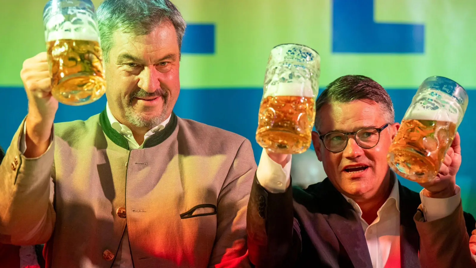 Markus Söder (l, CSU), Ministerpräsident von Bayern, und Boris Rhein (r, CDU), Ministerpräsident von Hessen, stoßen beim Politischen Frühschoppen Gillamoos gemeinsam auf der Bühne mit einer Maß Bier an.  (Foto: Peter Kneffel/dpa)