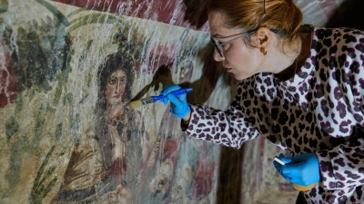 Eine Archäologin reinigt in der Türkei ein Fresko in einem Grab aus dem 3. Jahrhundert. Eine seltene, frühchristliche Darstellung von Jesus wurde in dem Grab entdeckt  (Foto: Khalil Hamra/AP/dpa)