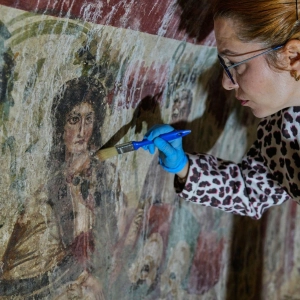 Eine Archäologin reinigt in der Türkei ein Fresko in einem Grab aus dem 3. Jahrhundert. Eine seltene, frühchristliche Darstellung von Jesus wurde in dem Grab entdeckt  (Foto: Khalil Hamra/AP/dpa)
