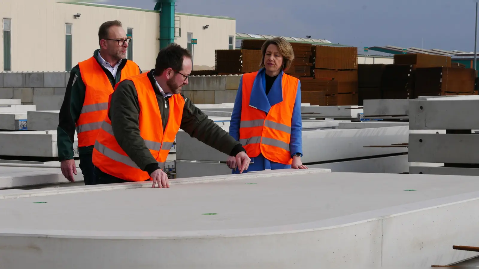 Michael Klaus und David Frey von der Geschäftsleitung zeigen der Bundestagsabgeordneten Anja Weisgerber die Betonfertigteile, die im GollIpp gefertigt werden, hier zum Beispiel Balkone in jeder erdenklichen Form. (F.: U.Ganter)