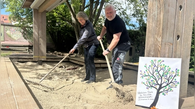 Acht Tonnen Sand wollen verteilt sein: Unternehmer Jürgen Wolf und Kiga-Leiterin Andrea Lang packten selbst mit Rechen und Schaufel an. (Foto: Florian Pöhlmann)