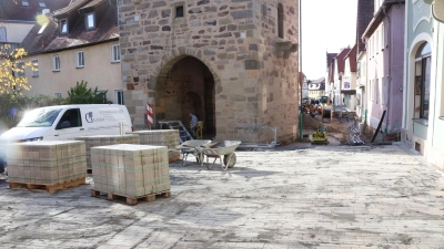 Von der Ampelkreuzung bis zum Torturm, in dessen Durchfahrt noch die Sandsteinarbeiten laufen, ist inzwischen das Gehwegpflaster verlegt, so dass zum Beispiel auch der Friseurladen wieder durch seinen Haupteingang zugänglich ist. (Foto: Andreas Reum)