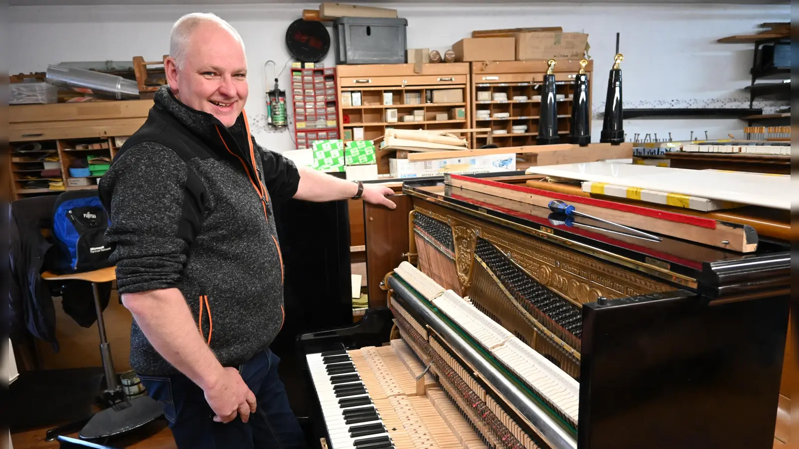 Rainer Wiedemann ist Klavierbaumeister aus dem Landkreis Ansbach. Hier ist er mit einem frisch reparierten Instrument in seiner Werkstatt zu sehen. (Foto: Anna Beigel)