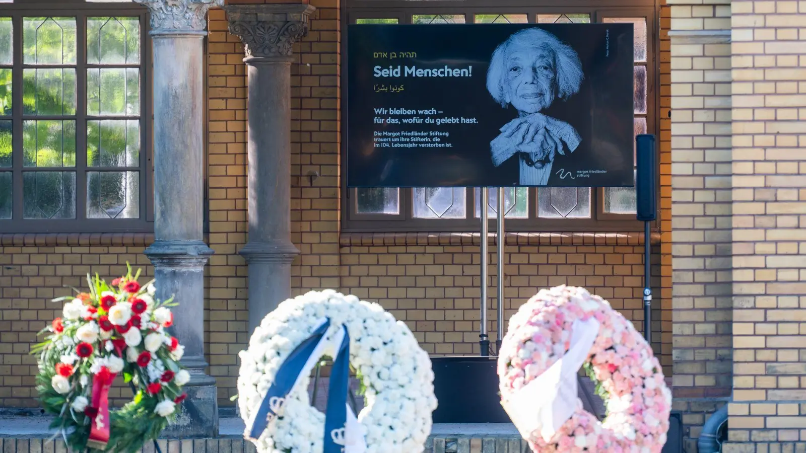 Am Tag der Beisetzung der Holocaust-Überlebenden Margot Friedländer stehen Kränze und ein Bild von Friedländer auf dem Jüdischen Friedhof Weißensee.  (Foto: Christophe Gateau/dpa)