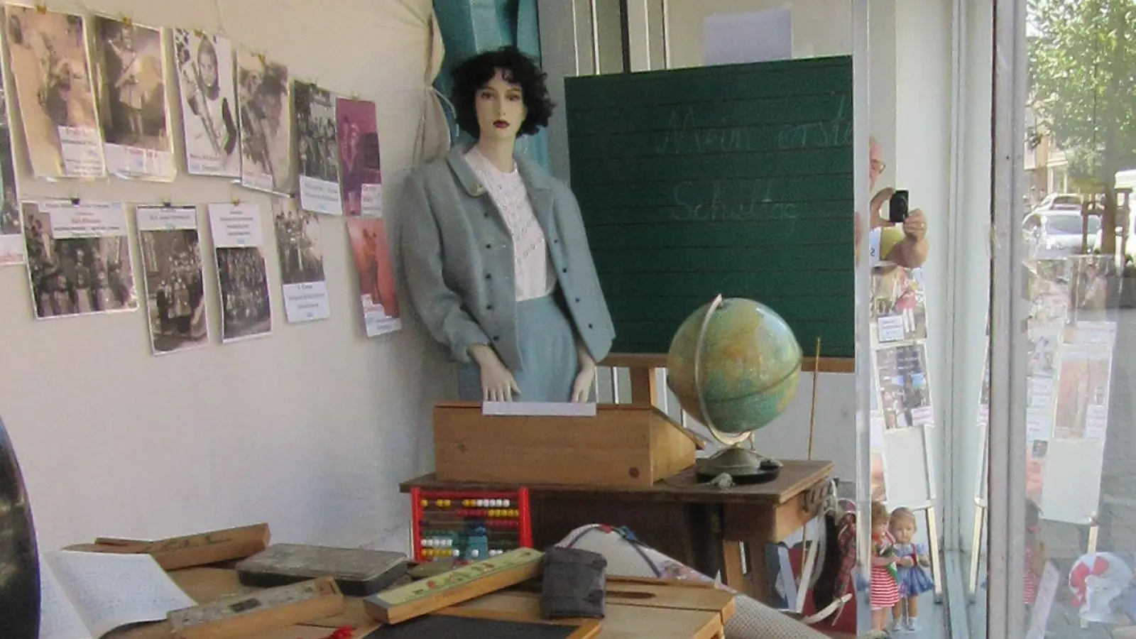Klaudia Schmidt und Wolfram Schmidt zeigen in einem leerstehenden Schaufenster in der Wilhelmstraße ein nachgestelltes Klassenzimmer. (Foto: Klaudia Schmidt)