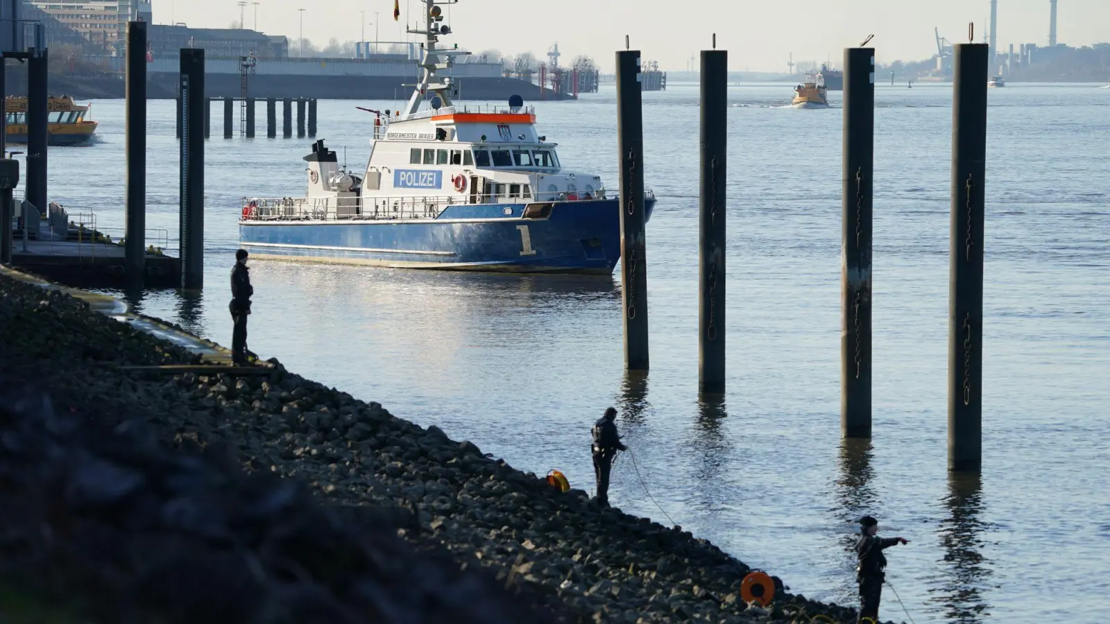 Polizeitaucher und Polizeibeamte bei der Suche nach dem Jungen in der Elbe. (Foto: Marcus Brandt/dpa)