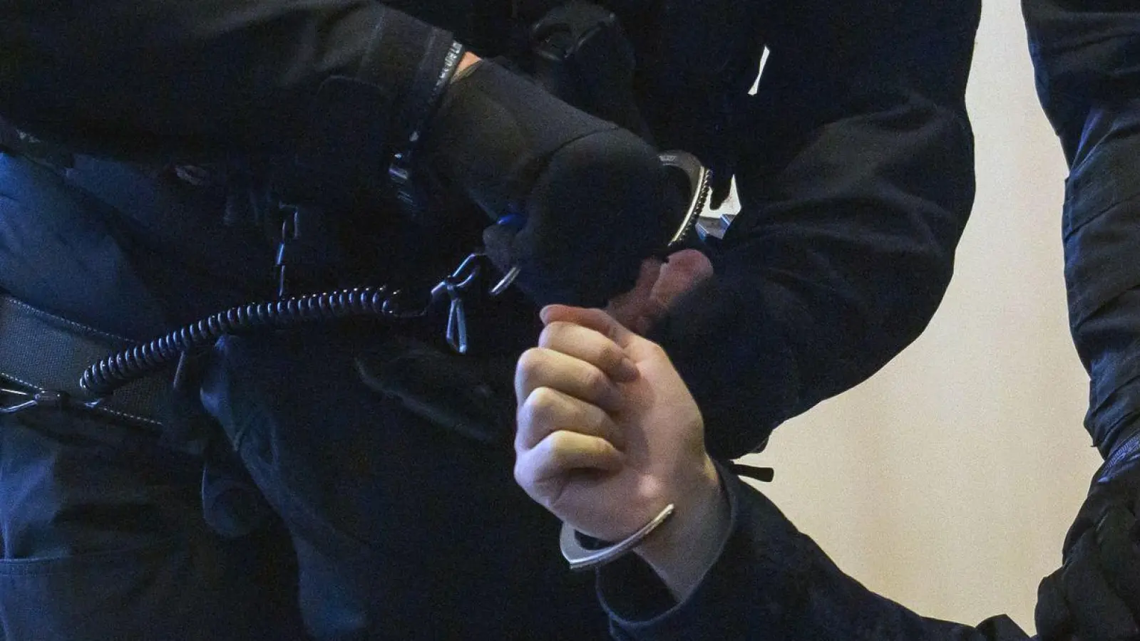 Justitzbeamte nehmen dem Angeklagten im Gerichtssaal die Handschellen ab. (Foto: Klaus-Dietmar Gabbert/dpa)