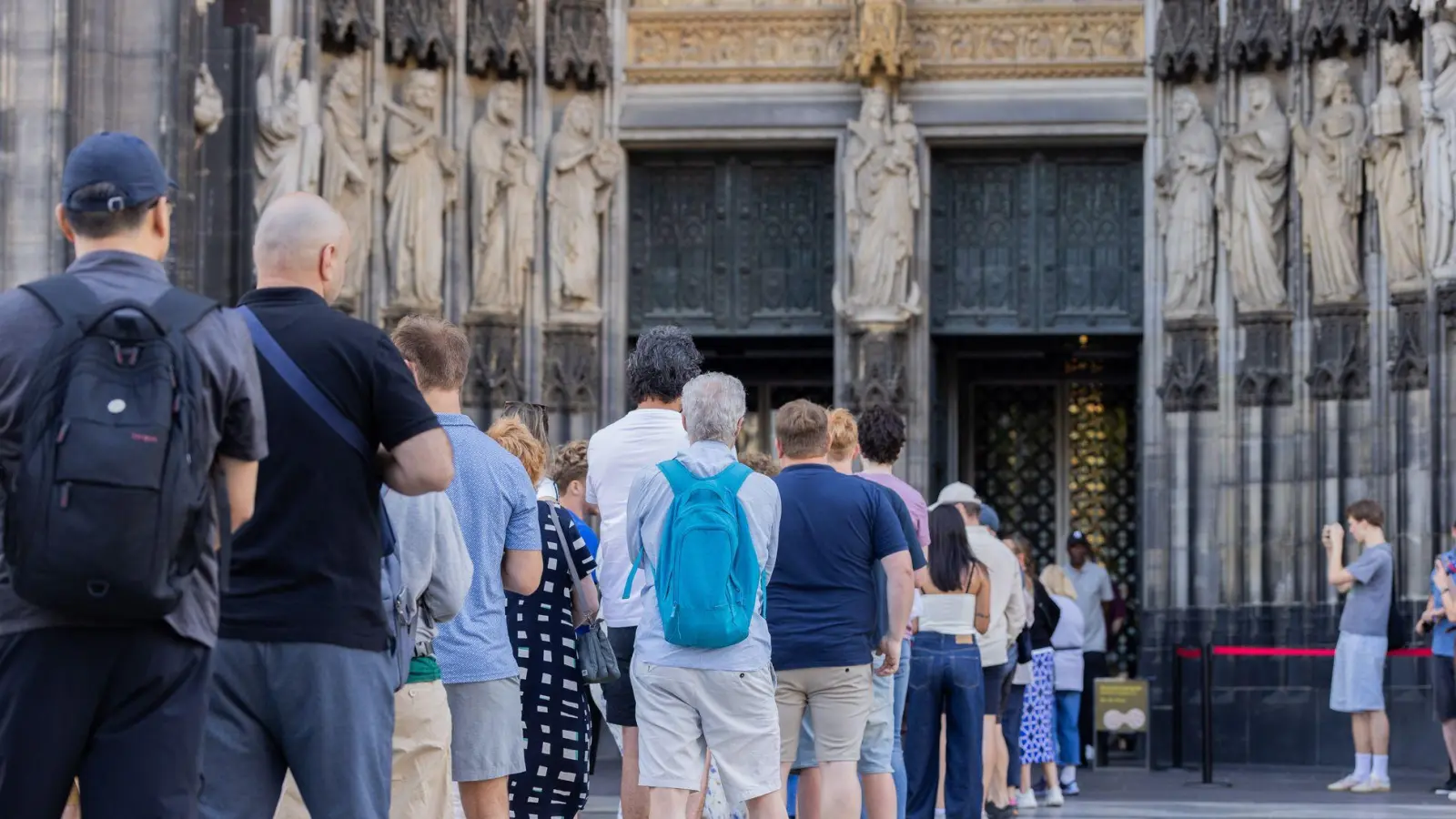 Vor Einlassbeginn bildete sich eine kleine Schlange vor dem Dom-Haupteingang. (Foto: Rolf Vennenbernd/dpa)