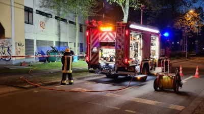 Ein Feuerwehrmann steht neben dem Wrack eines Autos, in dem zwei junge Männer aus der obersten Etage eines Parkhauses gestürzt und ums Leben gekommen sind. (Foto: Markus Gayk/TNN/dpa)