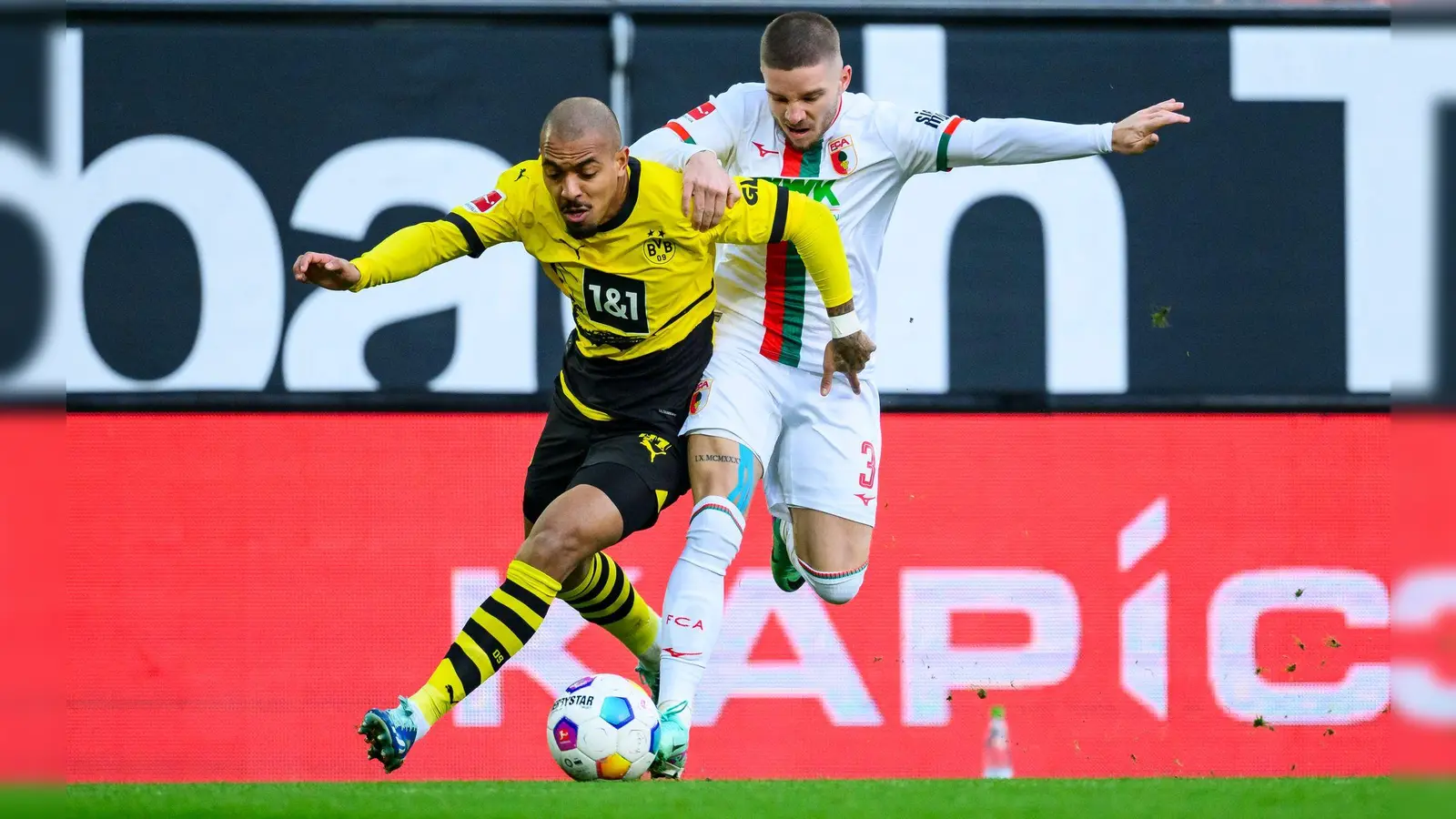 Dortmunds Donyell Malen (links) kämpft gegen Augsburg Mads Pedersen um den Ball. (Foto: Tom Weller/dpa)