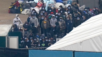 Eine Gruppe von Personen, bei denen es sich vermutlich um Migranten handelt, wartet auf ihre Registrierung in Dover. (Foto: Gareth Fuller/PA Wire/dpa)