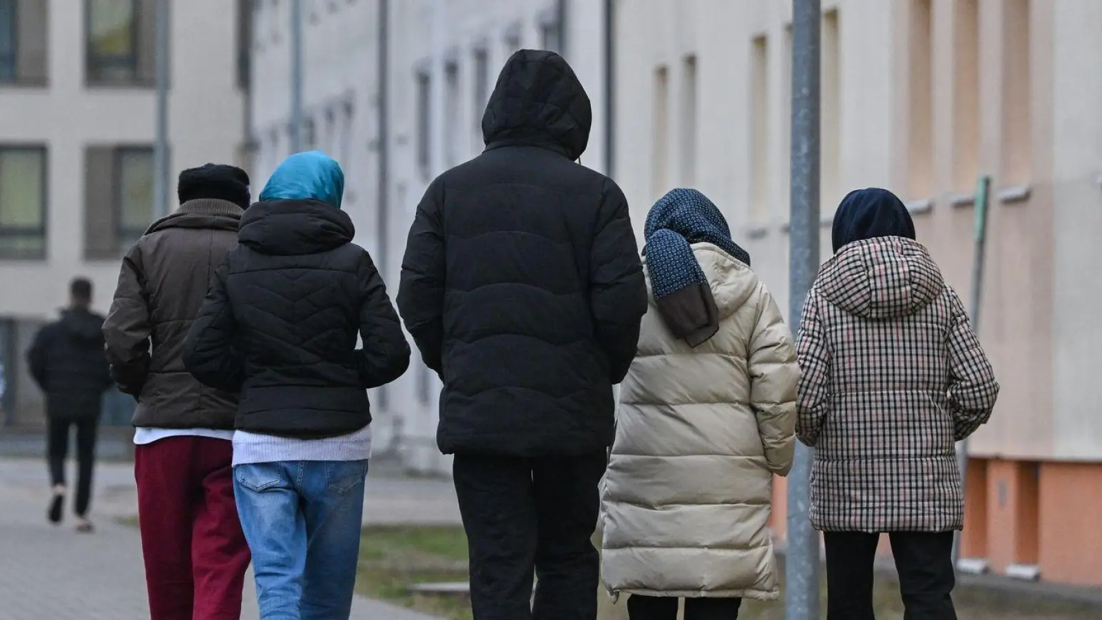 Migranten gehen über das Gelände der Zentralen Erstaufnahmeeinrichtung für Asylbewerber des Landes Brandenburg in Eisenhüttenstadt. (Foto: Patrick Pleul/dpa)