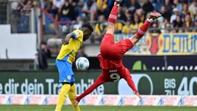 Düsseldorfs Giovanni Haag (r) mit einer akrobatischen Einlage gegen Braunschweig Richmond Tachie. (Foto: Swen Pförtner/dpa)