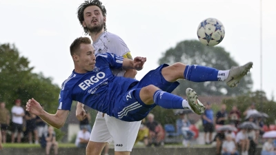 Ein Akrobat: Tim Baumann (Neuses) legt sich quer, um den Ball zu spielen, bestaunt vom Herrieder Tom Plohmer. (Foto: Martin Rügner)