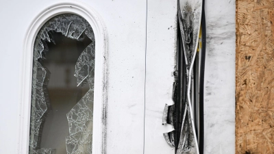 Eine zerstörte Eingangtür in dem Ort Seckach. Mutmaßlich wurde hier der Tatverdächtige von einem Einsatzkommando der Polizei festgenommen. (Foto: Bernd Weißbrod/dpa)