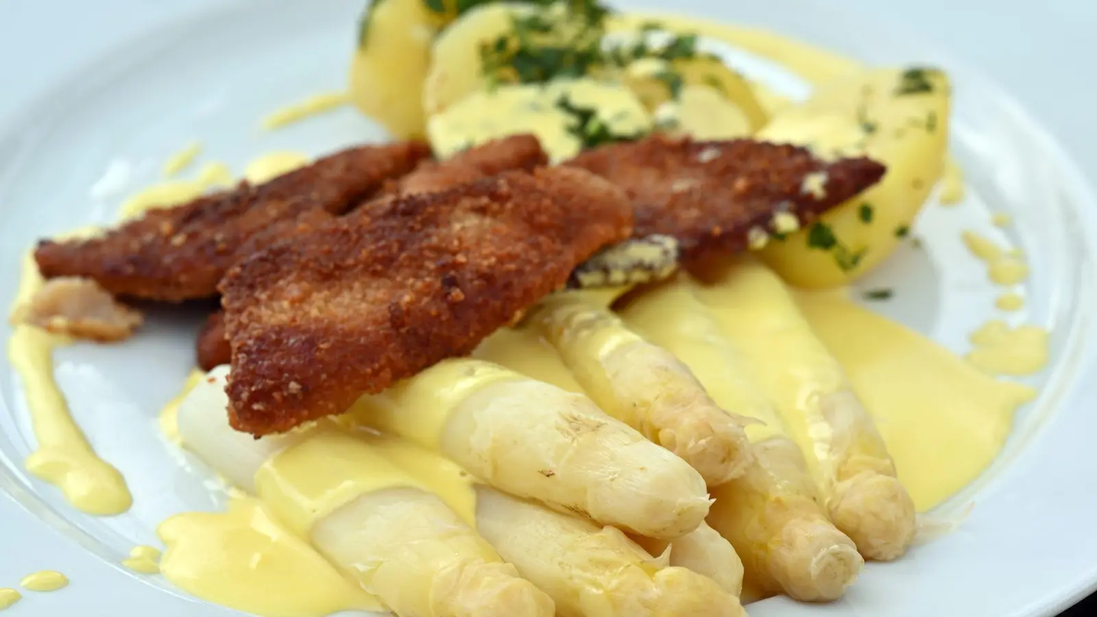 Diejenigen, die Spargel mögen, essen ihn am liebsten mit Sauce hollandaise (einer Soße, die ursprünglich nur aus Butter, Eigelb und einer Reduktion aus Weißwein besteht). (Archivbild) (Foto: Martin Schutt/dpa)