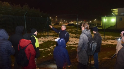 Die Lichterdemo endete am Zaun der US-Kaserne in Katterbach. Wolfgang Schmidt, Sprecher der Bürgerinitiative „Etz langt’s!“, kritisierte, dass noch nichts passiert sei, um die Ausbreitung der Chemikalien einzuschränken und den Boden zu sanieren. (Foto: Florian Schwab)