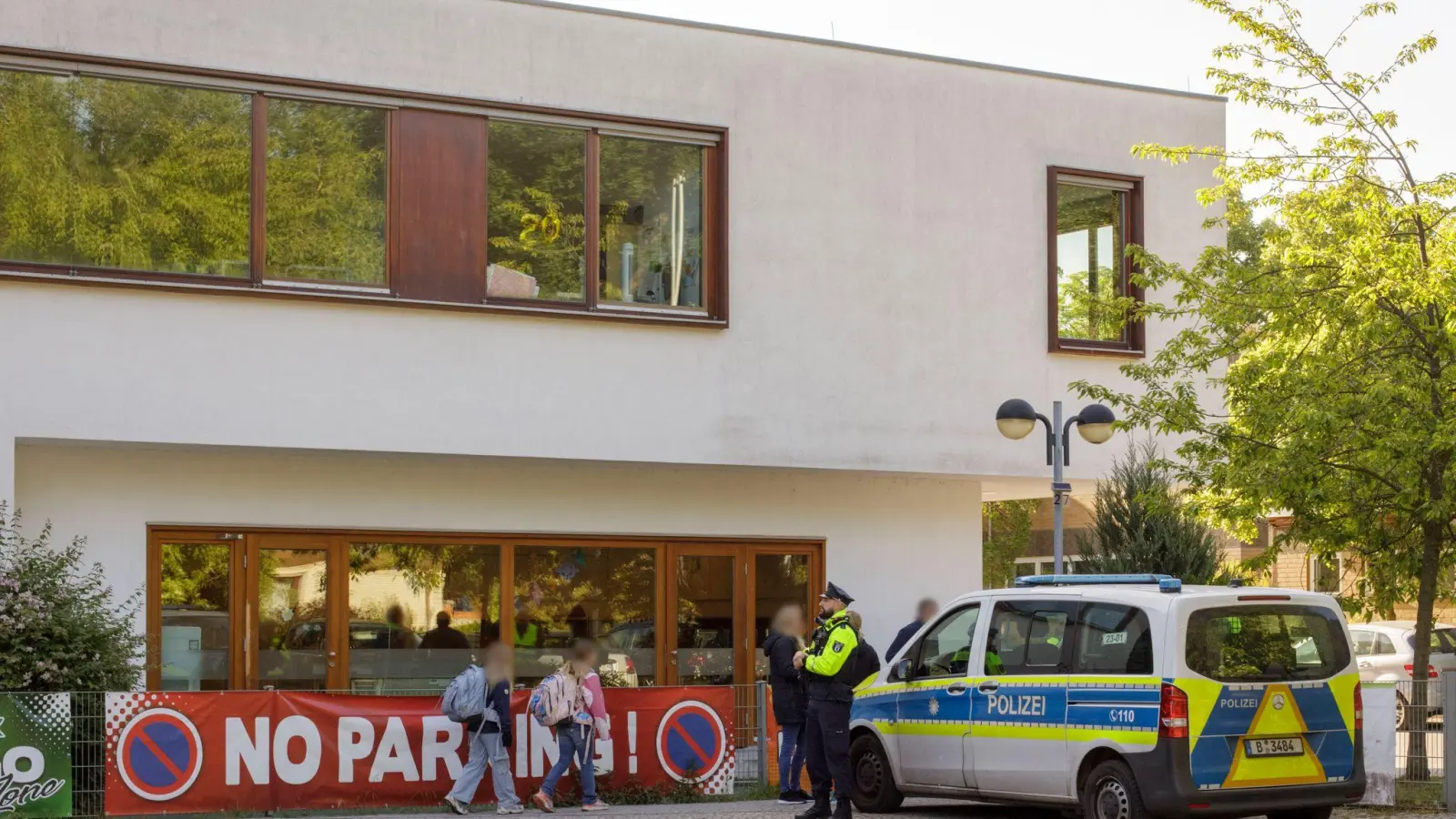 Die Polizei steht vor einer Grundschule im Berliner Bezirk Spandau, während Schüler am Morgen zur Schule kommen.  (Foto: Julius-Christian Schreiner/dpa)