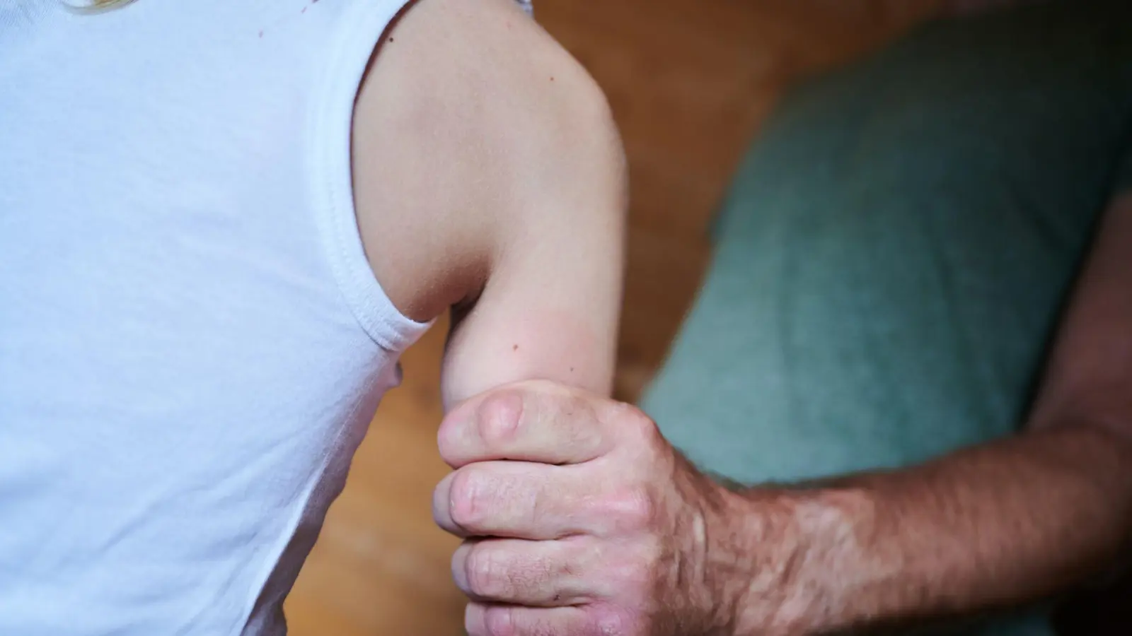 Ein Mann hält ein Kind fest am Arm (gestellte Szene). (Symbolbild) (Foto: Annette Riedl/dpa)