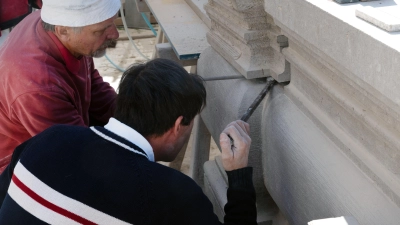 Richard Novak (links) und Ronny Kolbe schieben einen neuen Stein an Ort und Stelle. Dabei ist millimetergenaues Arbeiten erforderlich. (Foto: Irmeli Pohl)