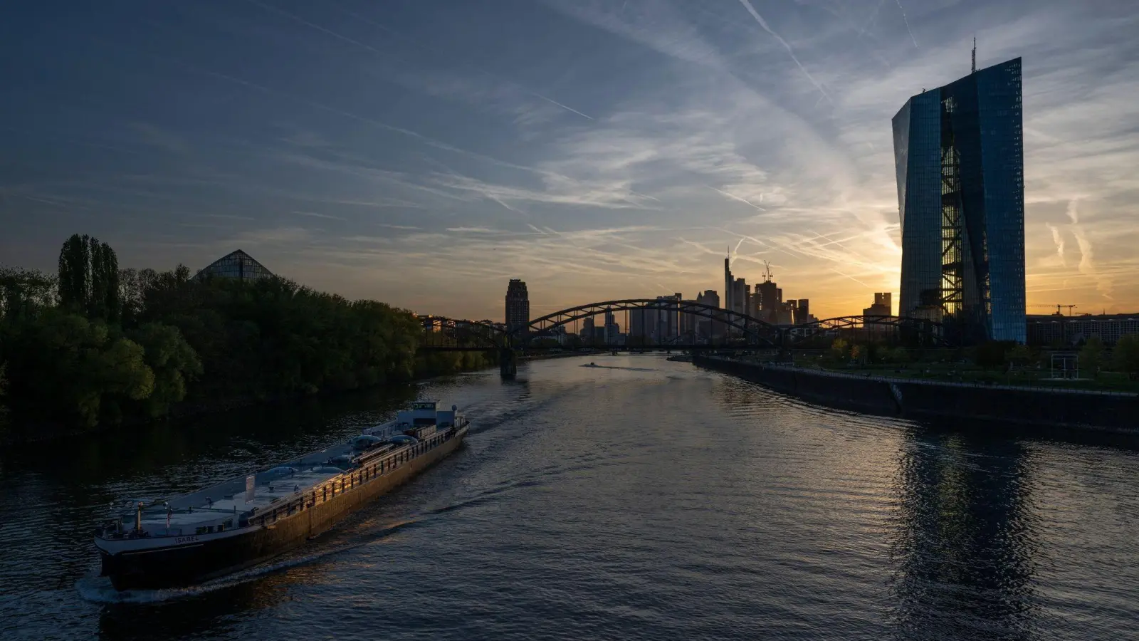 Ein Schiff fährt bei Sonnenuntergang an der EZB in Frankfurt vorbei. (Foto: Boris Roessler/dpa)