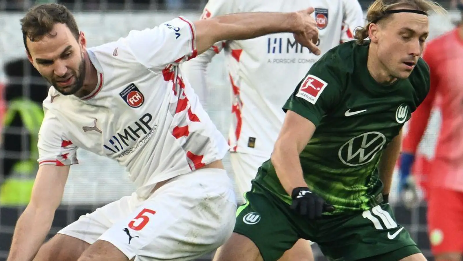 Wolfsburgs Lovro Majer (r) wird vom Heidenheimer Benedikt Gimber bedrängt. (Foto: Swen Pförtner/dpa)