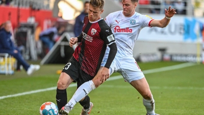 Denis Linsmayer von Ingolstadt (l) kämpft mit Simon Lorenz von Kiel um den Ball. (Foto: Armin Weigel/dpa)