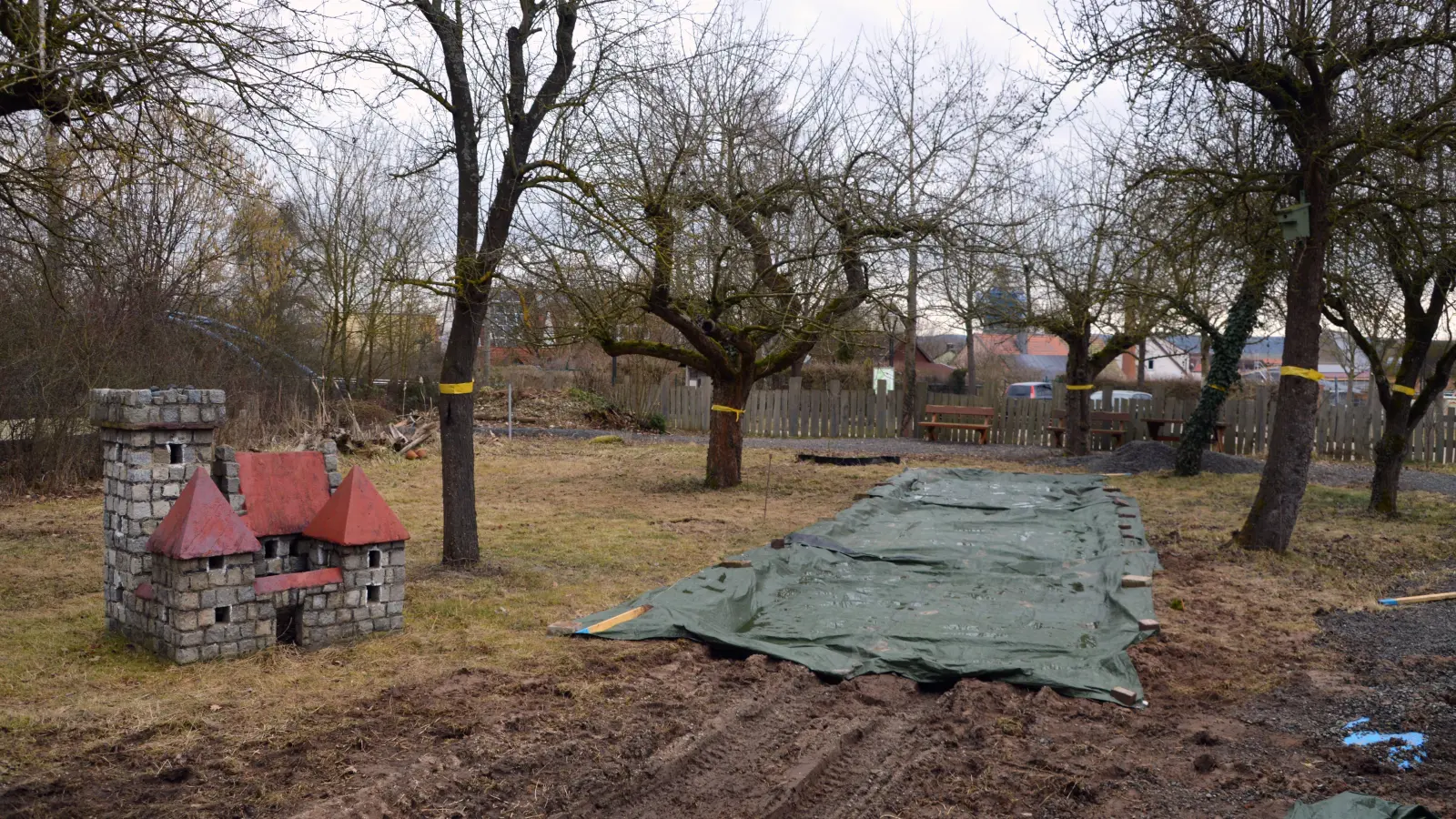 Die Arbeiten am kleinen Bürgerpark neben dem Uehlfelder Rathaus haben begonnen. Die im Bau befindliche Boule-Bahn ist noch mit einer Plane abgedeckt, die Ritterburg bleibt vorerst unerobert. (Foto: Johannes Zimmermann)