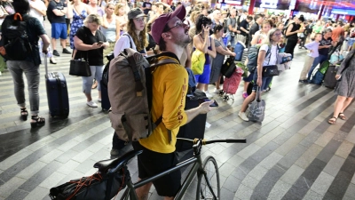 Passagiere sitzen in der Halle des Prager Hauptbahnhofs wähtrend eines Stromausfalls.  Ein Stromausfall hat am Freitag große Teile Tschechiens und der Millionenmetropole Prag lahmgelegt. (Foto: Vondrouš Roman/CTK/dpa)