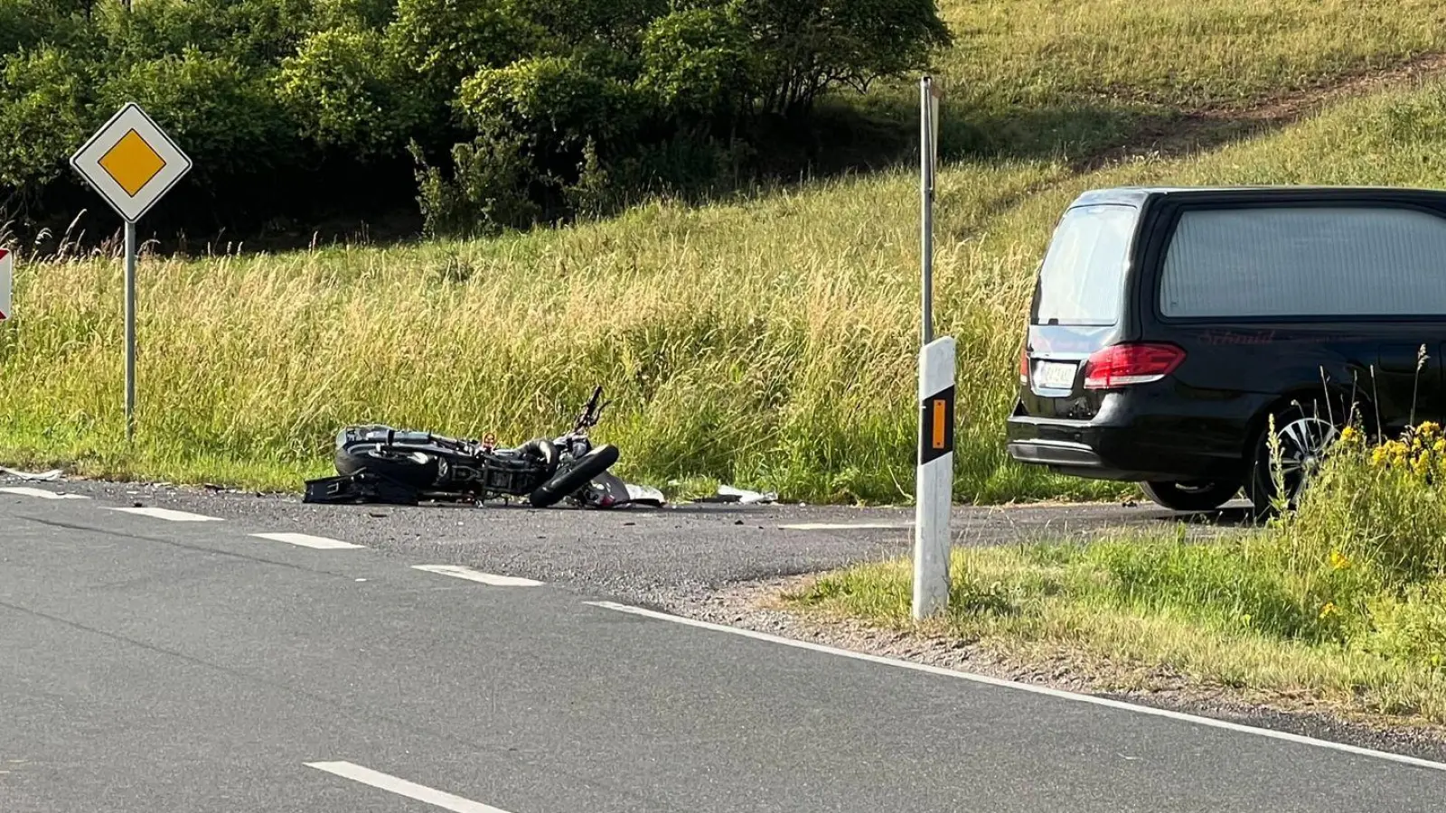 Das Fahrzeug eines Bestatters steht nach einem Unfall neben einem Motorrad, das am Boden liegt. (Foto: -/NEWS5/dpa)