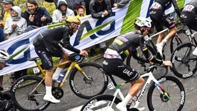 Olympiasieger Remco Evenepoel (M) mit goldenem Helm an der Mauer von Huy. Rechts neben ihm Tadej Pogacar. (Foto: Jasper Jacobs/Belga/dpa)