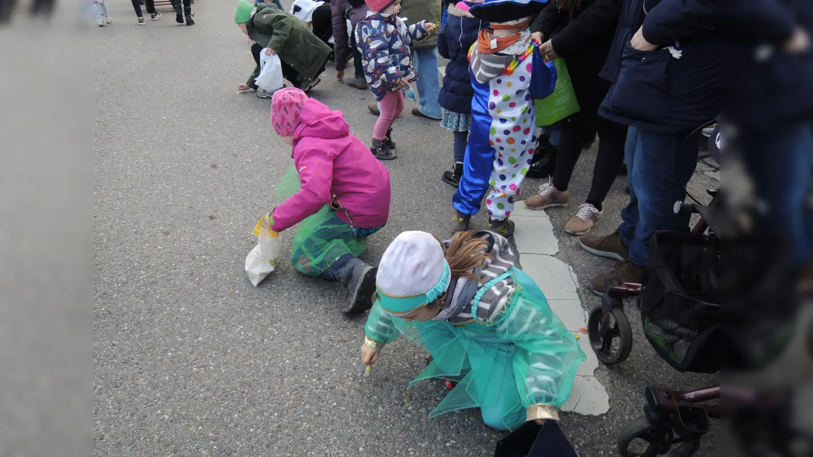 Nach jedem Bonbonregen sammelten die Kinder die Süßigkeiten emsig von der Straße.<br> (Foto: Peter Zumach)