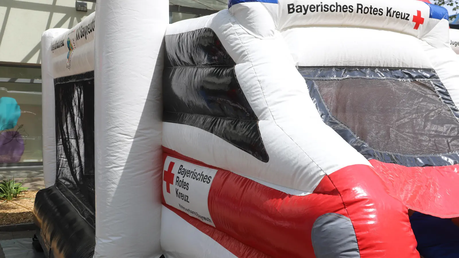 Eine Hüpfburg in Form eines Rettungswagens ist auf dem Gelände des Brücken-Centers für die Kinder aufgebaut. (Foto: Oliver Herbst)