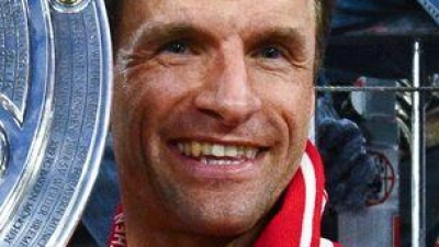 Thomas Müller zeigt die Meisterschale. (Foto: Tom Weller/dpa)