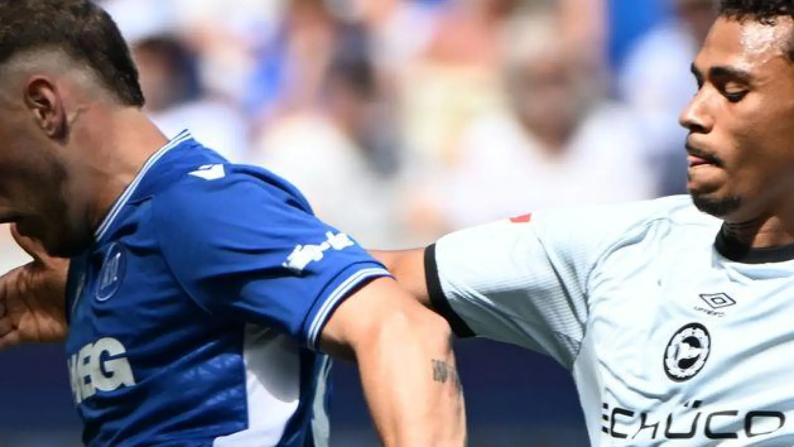 Auch mal die Linie entlang: Karlsruhes Noel Eichinger (l) im Duell mit dem Bielefelder Henri Koudossou.  (Foto: Uli Deck/dpa)