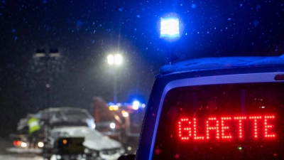Auf der verschneiten Bundesstraße 12 warnt an einer Unfallstelle ein Polizeifahrzeug vor Glätte. (Foto: Stefan Puchner/dpa)