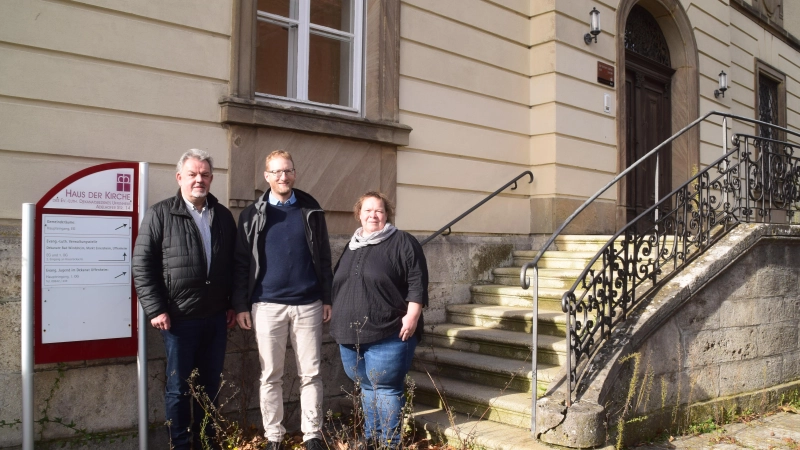 Auf der Pflasterfläche hat die Natur schon für Leben gesorgt, bald wird auch wieder Leben in das alte Haus der Kirche in Uffenheim einziehen. Das Gebäude hat einen neuen Eigentümer. Darüber informierten (von links) Hermann Schuch, Max von Egidy und Andrea Wangler-Himmelein. (Foto: Gerhard Krämer)