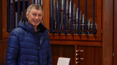 Stefan Ubl, der künstlerische Leiter der Stiftsbasilikakonzerte Herrieden, leitet am Sonntag die Aufführung der Passion von Heinrich Fidelis Müller, hinter ihm die geliehene Chororgel, die auch im Konzert erklingt. (Foto: Thomas Wirth)