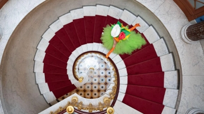 Eine als Blumenmädchen verkleidete Darstellerin geht am Rande einer Pressekonferenz zur Dresdner Schlössernacht im Schloss Albrechtsberg über eine Treppe.  (Foto: Sebastian Kahnert/dpa)