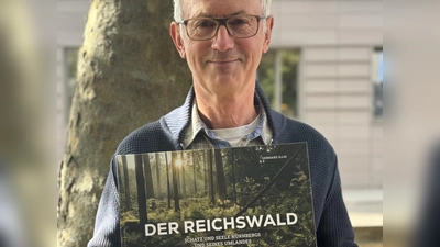 Der Fotograf Gerhard Illig mit seinem druckfrischen Bildband über den Nürnberger Reichswald.  (Foto: Lara Hausleitner)