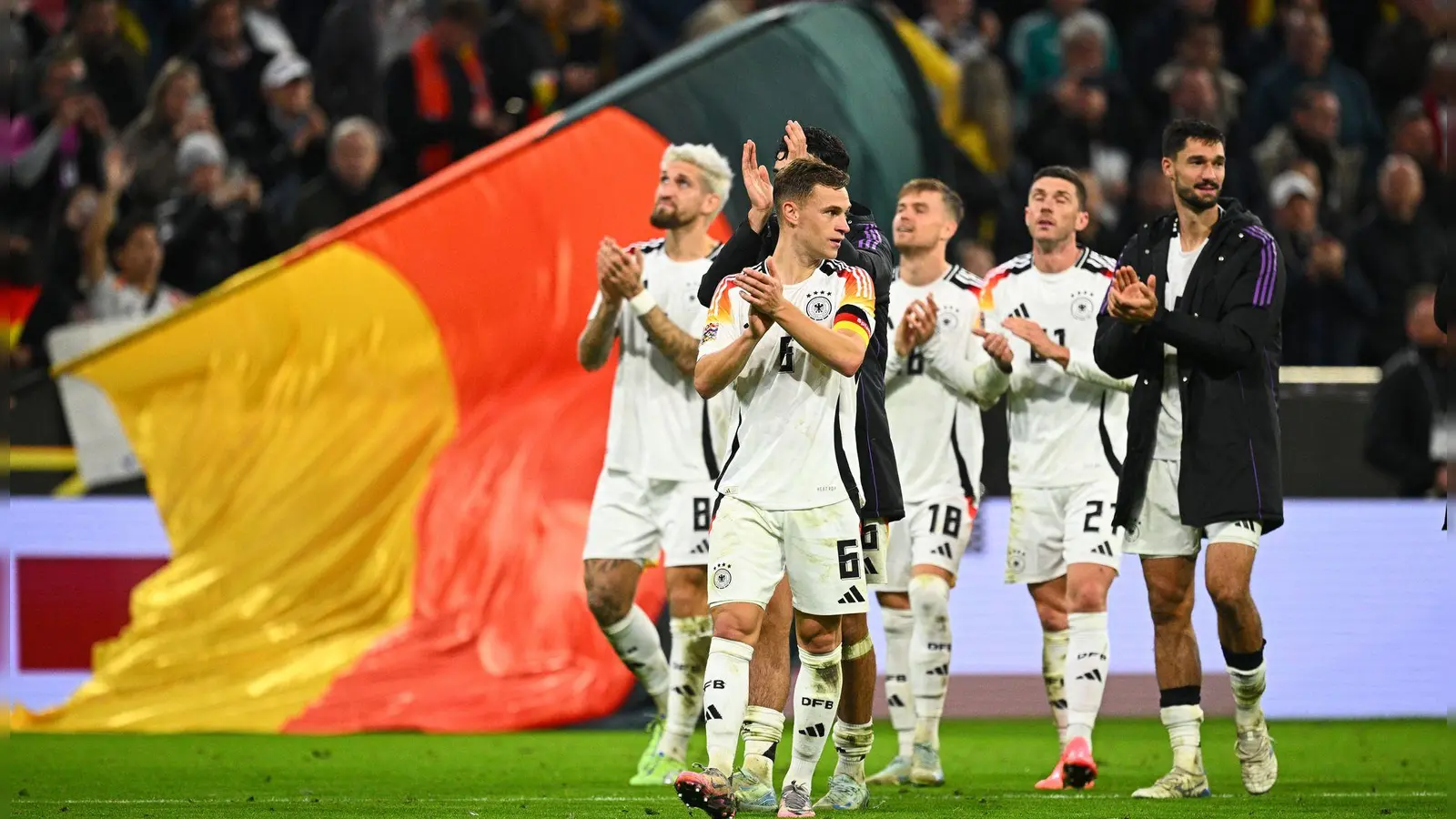 Glückliche deutsche Spieler um Kapitän Joshua Kimmich (vorne) auf der Jubelrunde durch das Stadion. (Foto: Tom Weller/dpa)