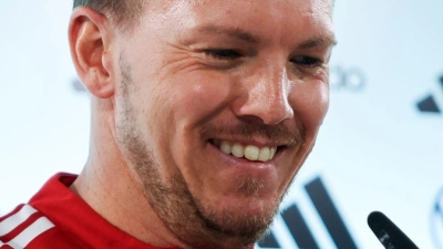 Julian Nagelsmann richtet das Mikrofon bei der Pressekonferenz.  (Foto: Christian Charisius/dpa)