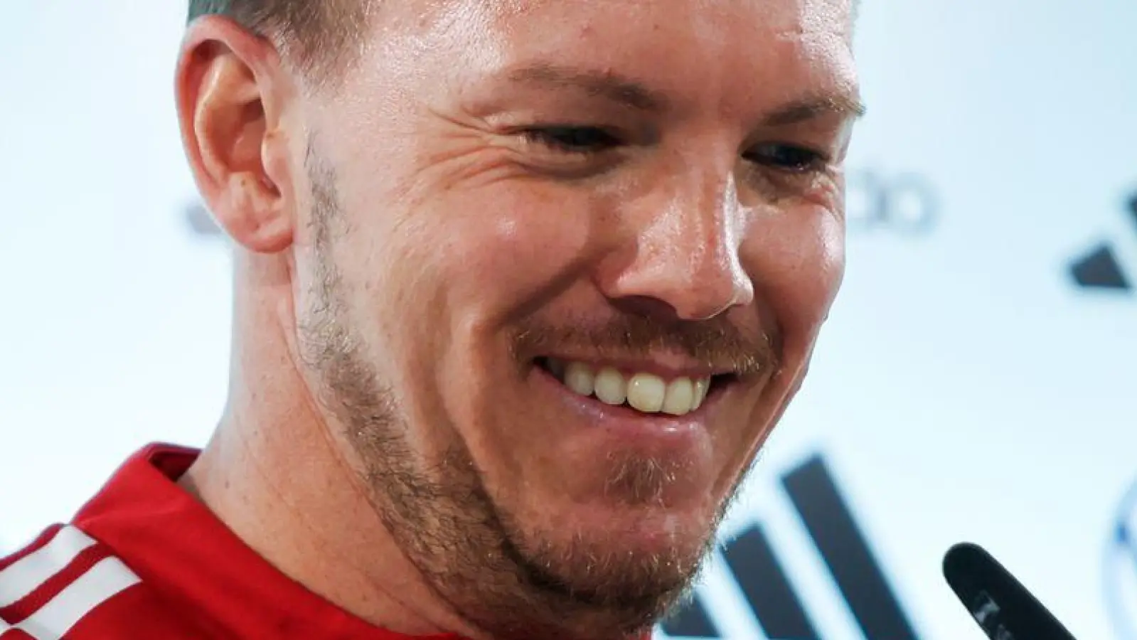 Julian Nagelsmann richtet das Mikrofon bei der Pressekonferenz.  (Foto: Christian Charisius/dpa)