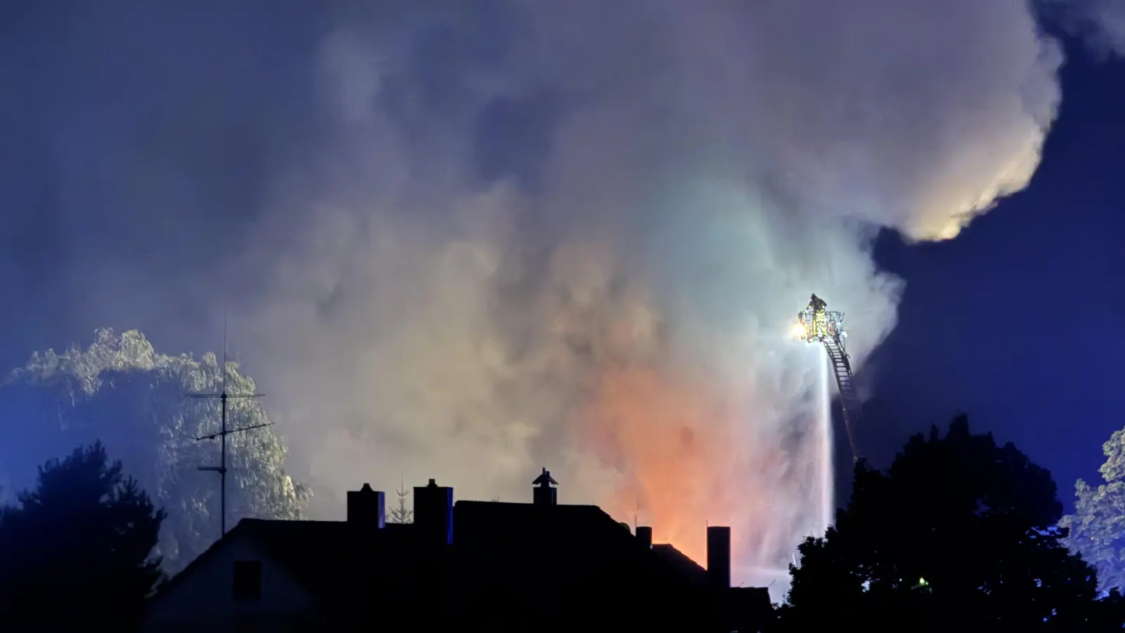 Kurz vor 23 Uhr schlagen wieder höhere Flammen aus der Halle. Die Bevölkerung wird gebeten, Fenster und Türen wegen gefährlicher Gase geschlossen zu halten.  (Foto: Lara Hausleitner)