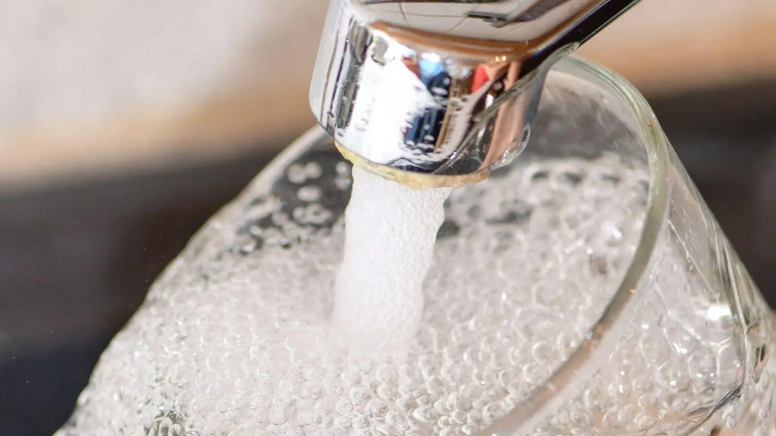 Eine Frau füllt ein Glas mit Trinkwasser aus dem Hahn. (Foto: Patrick Pleul/dpa-Zentralbild/dpa)