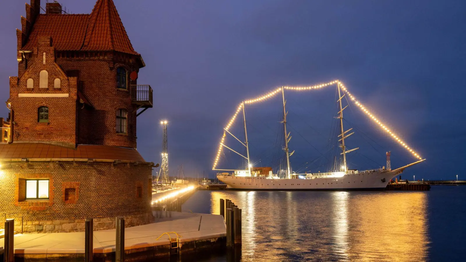 Weihnachtlich geschmückt: Die „Gorch Fock 1“ strahlt im Stralsunder Hafen mit Lichterkette. (Foto: Stefan Sauer/dpa)