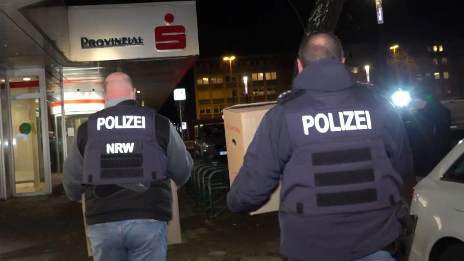 Mehrere Kisten mit Beweismaterial aus der Sparkassenfiliale sicherten Polizeibeamte am Abend. (Foto: Markus Gayk/dpa)