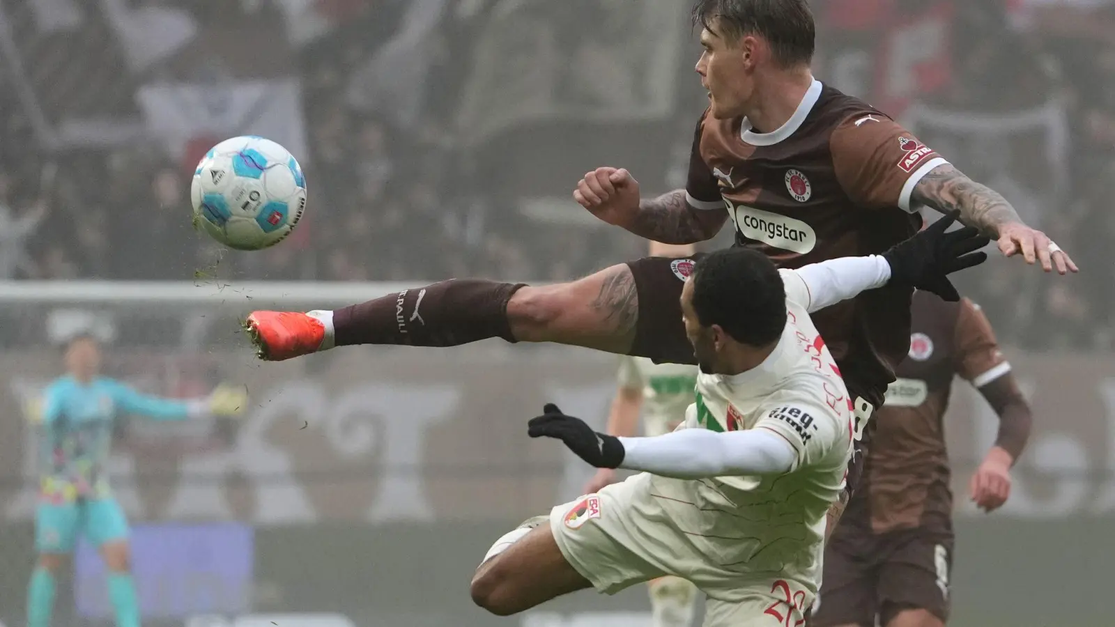  St. Paulis Eric Smith (r) und Augsburgs Alexis Claude-Maurice kämpfen um den Ball. (Foto: Marcus Brandt/dpa)